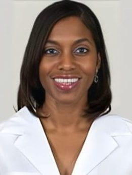 Rochelle Naylor, Smiling and looking forward wearing a white lab coat that reads UChicago medicine
