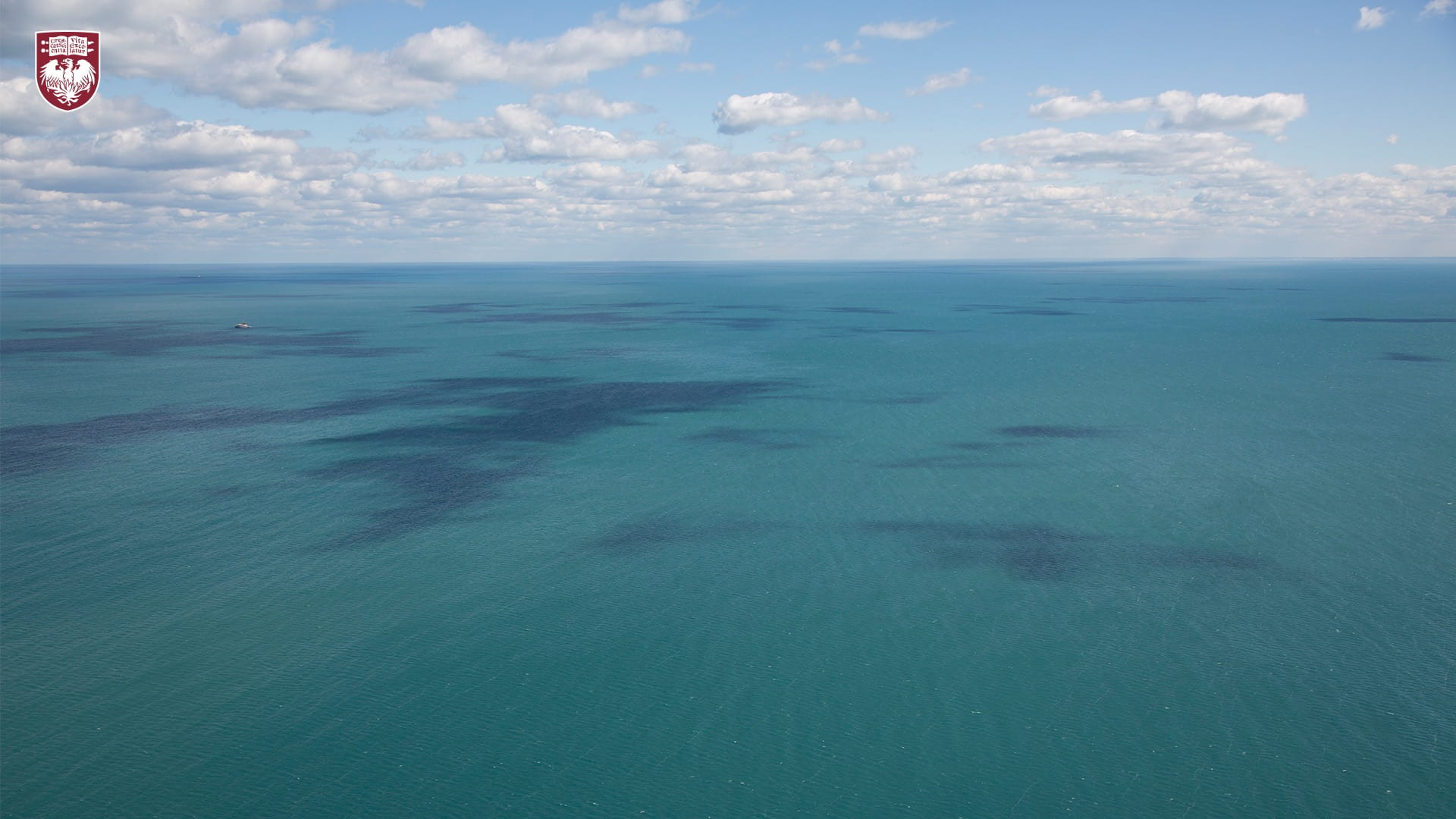 Aerial view of Lake Michigan’s blue water and blue sky with clouds